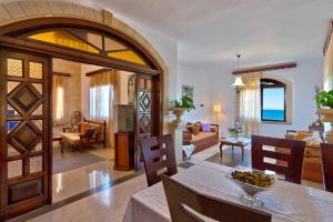 a living room with a dining table and a living room at Thodorou Sunset Villa in Stalos