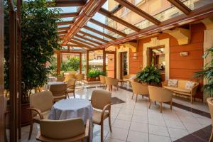 een serre met tafels en stoelen in een restaurant bij Hotel Careni Villa Italia in Finale Ligure