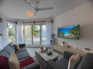 a living room with a blue couch and a tv at Zuri Twin Sands Beach Properties - Malindi in Malindi