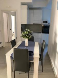a kitchen with a table with a vase of flowers on it at La Casa dei colori in Vico Equense