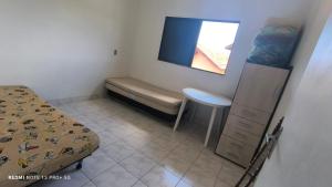 ein kleines Schlafzimmer mit einem Bett und einem Fenster in der Unterkunft Bertioga pé na areia in Bertioga + 4 Fotos