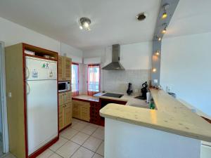 a kitchen with a white refrigerator and a counter at Les forestiers 2 in Mimizan