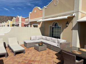 een patio met een bank en een tafel en stoelen bij Paraiso Ocean View in Palm-mar