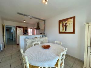 a kitchen and dining room with a table and chairs at Les forestiers 2 in Mimizan +5 photos