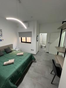 a bedroom with a green bed and a desk at Triton Mansion D26 - Entire Unit in St Paul's Bay