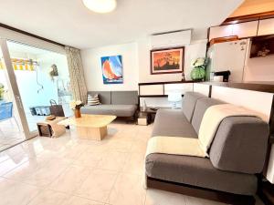 a living room with a couch and a table at Canopus sea views in Alcudia