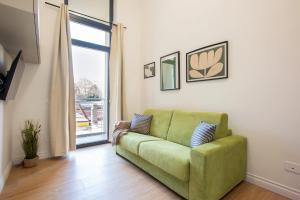 a green couch in a living room with a window at Urban Oasis near Termini, Free Parking&Balcony, int10 in Rome