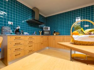 a kitchen with wooden cabinets and a basket of fruit on a table at AL Restaurante A Lampreia in Santa Comba Dão