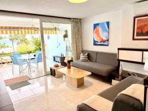 a living room with a couch and a table at Canopus sea views in Alcudia