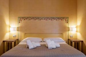 a bedroom with a bed with two pillows and two lamps at Rosaspina - Appartamento 4 in Capalbio +15 photos