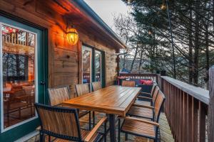 a wooden table and chairs on the porch of a cabin at Movie Theater Arcade Hot Tub Grill Views in McGaheysville +47 photos
