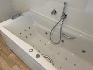 a white bath tub with a shower in a bathroom at Haus Gutach in Schonwald im Schwarzwald +24 photos