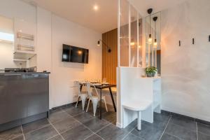 a kitchen and dining room with a table and chairs at Maison 2 chambres proche du tram, parking gratuit in La Madeleine