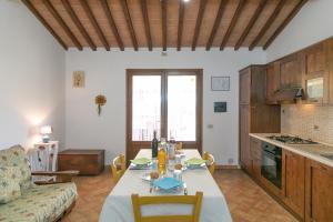 Una cocina y una sala de estar con una mesa y un sofá. en Il Pino - appartamento Tiglio, en Cecina