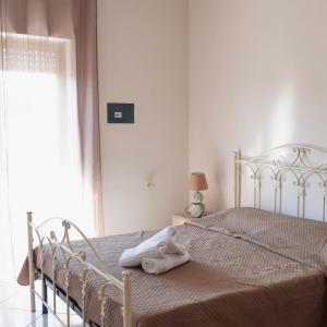 a bedroom with a bed with a blanket and a window at La Valle e il Mare - San Leone in San Leone