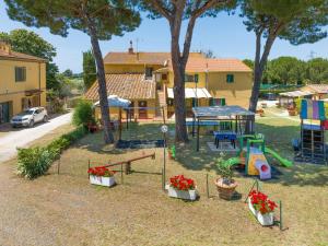 un patio trasero con parque infantil y equipo de juegos en Il Pino - appartamento Alloro, en Cecina