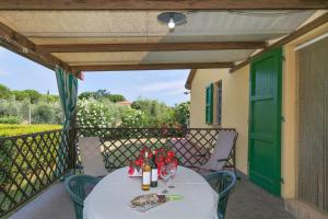 una mesa con botellas de vino y copas en el balcón en Il Pino - appartamento Mandorlo, en Cecina