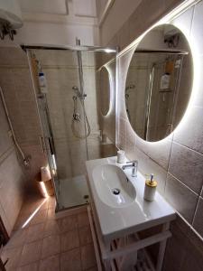 a bathroom with a sink and a shower and a mirror at KiKi House Bracciano in Bracciano +22 photos