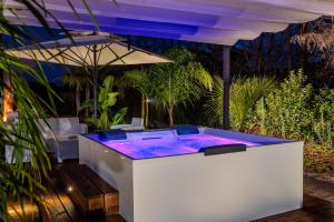 a hot tub with purple lighting on a patio at Villa Kalia Luxury by HDSalento in Aradeo