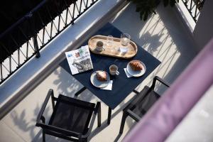 a table with a plate of food on a balcony at AthenSun Luxury Suites in Athens