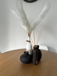 a group of vases sitting on a table with feathers at Appartement cosy à 5 min du centre-ville in Liège