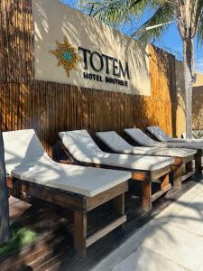 a group of chairs and a hotel sign on a wall at Hotel TOTEM Boutique in Termas de Río Hondo