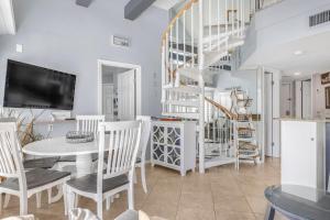 ein Wohnzimmer mit einem Tisch und Stühlen sowie einer Wendeltreppe in der Unterkunft GS Plantation West 1339 by Vacation Homes Collection in Gulf Highlands