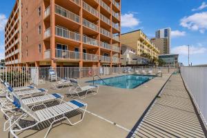 a swimming pool with lounge chairs and a building at Buena Vista 302 by Vacation Homes Collection in Gulf Shores