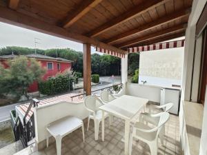 a patio with a table and chairs on a balcony at Lidia in Rosolina