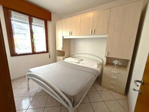 a small bedroom with a bed and a window at Lidia in Rosolina