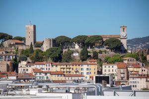a city with buildings and a clock tower on a hill at L'Esterel in Cannes