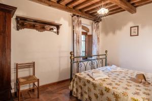 un dormitorio con una cama y una silla en Agriturismo Fadanelli - Il Granaio, en Lamporecchio