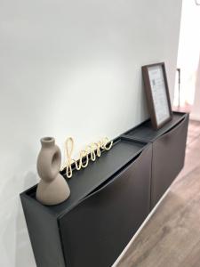 Un tocador negro con un jarrón encima. en Appartement cosy à 5 min du centre-ville, en Lieja