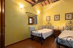 a bedroom with two beds and a mirror at Podere San Bartolo- Fienile in Barberino di Val dʼElsa