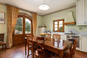 a kitchen with a wooden table and a dining room at Podere San Bartolo- Fienile in Barberino di Val dʼElsa