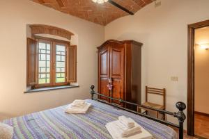 Un dormitorio con una cama y un armario de madera. en Agriturismo Fadanelli - La Cantina, en Lamporecchio 15 fotos más