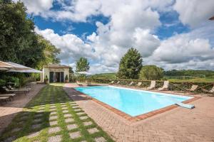 una piscina con sillas y un patio en Appartamento Ocra, en Asciano