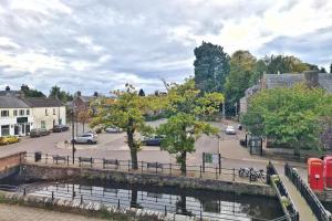 a town with a river and a street with cars at The Alyth Hotel in Alyth