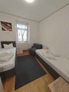 维也纳ABAI Apartments 1140 only WWW-On-line-Check-in & SelfService的白色的客房配有两张床和黑色地毯。 更多11张照片