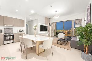 a kitchen and living room with a table and chairs at SML Vacation Homes - Sky High Apartments with Burj Khalifa and Dubai Fountain Views at Grande Signature, Downtown Dubai in Dubai