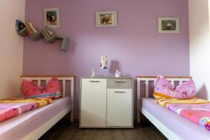 two beds in a room with pink walls at Ferienwohnung Mit Zwei Schlafzimmern Und Balkon in Weißenstadt