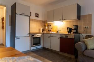 a kitchen with white cabinets and a white refrigerator at Ferienwohnung Mit Zwei Schlafzimmern Und Balkon in Weißenstadt +26 photos