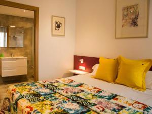 ein Schlafzimmer mit einem Bett mit gelben Kissen und ein Badezimmer in der Unterkunft Ferienhaus in Torroella De Montgrí mit Privatem Pool in Torroella de Montgrí