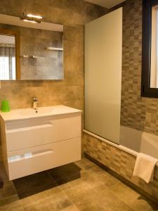 ein Badezimmer mit einem weißen Waschbecken und einer Badewanne in der Unterkunft Ferienhaus in Torroella De Montgrí mit Privatem Pool in Torroella de Montgrí