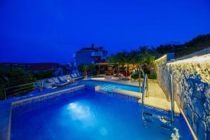 ein großer Pool mit blauem Wasser in der Nacht in der Unterkunft Ferienhaus in Ražanj mit Großem Garten in Ražanj