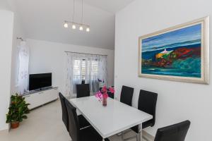 ein Esszimmer mit einem weißen Tisch und Stühlen in der Unterkunft Ferienhaus in Ražanj mit Großem Garten in Ražanj