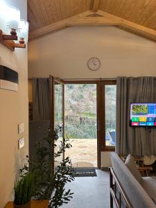 a living room with a clock on the wall at Riverside Jahliye, Chouf in Al Jāhilīyah