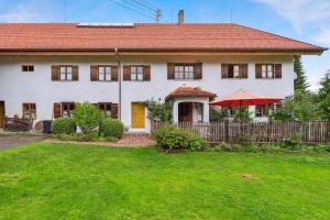 a white house with a red roof and a yard at Gemütliches Ferienhaus In Tannenberg in Burggen
