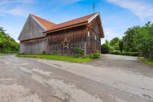 a large wooden barn with a star painted on the side at Gemütliches Ferienhaus In Tannenberg in Burggen
