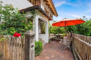 a patio with a table and an umbrella at Gemütliches Ferienhaus In Tannenberg in Burggen +32 photos